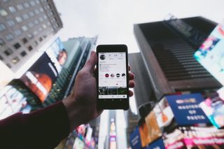 persona viendo post desde su celular en la ciudad