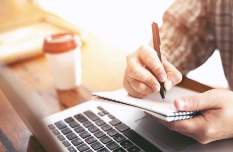 persona escribiendo notas en una libreta